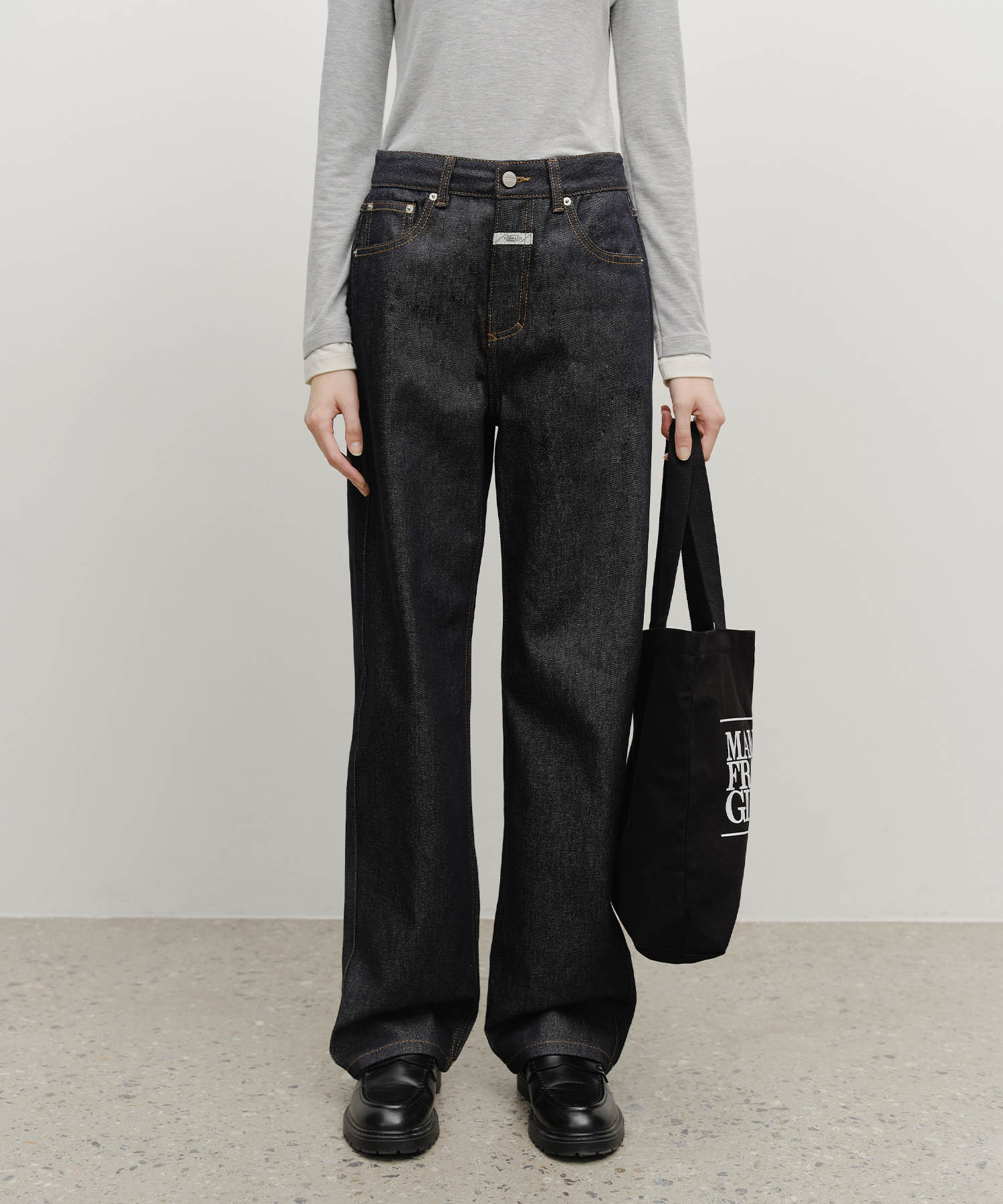 Marithé Classic Logo Eco Bag in black carried by hand, front view
